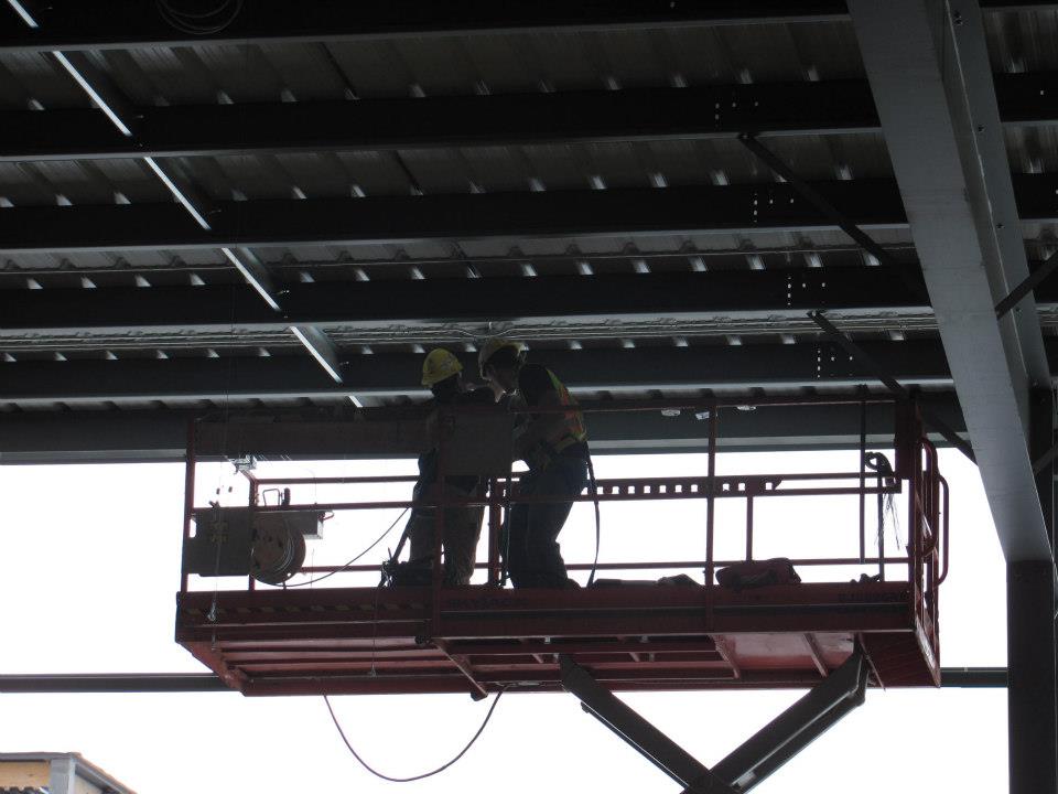 Topline Electric workers on a scaffold at a construction site